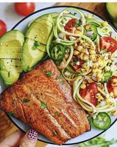 a plate with salmon, zucchini noodles and tomatoes