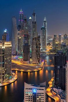 the city skyline is lit up at night with skyscrapers and other high rise buildings