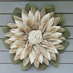 a large flower made out of burlocks on the side of a house wall