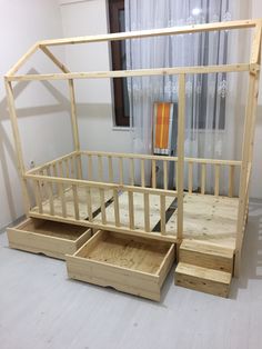 a wooden bed frame with two drawers on the bottom and an open window behind it