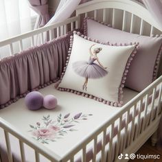 a white crib with pink and purple pillows on it