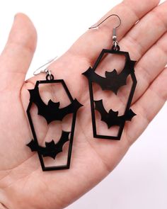 It's time to embrace the dark and dance in the moonlight! Unleash your inner nocturnal spirit with our Coffin Bat Earrings. Featuring a coffin silhouette with edgy bat cutouts. Perfect for those who love a little gothic charm intertwined with their beats, these earrings are bound to make hearts flutter. Coffin-meets-bat design that’s equal parts spooky and enchanting. Intricate detailing that captures the beauty of the night. Crafted for comfort, dance all night without a hitch. The ultimate acc Black Spooky Jewelry For Party, Spooky Black Jewelry For Party, Edgy Halloween Jewelry, Black Spooky Party Jewelry, Black Laser Cut Jewelry, Black Laser Cut Jewelry As Gift, Black Laser Cut Jewelry Gift, Black Halloween Evening Jewelry, Black Jewelry For Halloween Evening