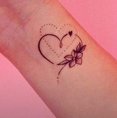 a small heart tattoo with flowers on the wrist