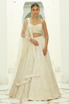 Ivory attached cancan flared lehenga with all-over tonal sequin, pastel beads, crystals embroidery in herringbone pattern. Paired with sweetheart neck embellished noodle strap padded blouse and border embroidered dupatta.
Components: 3
Pattern: Embroidery
Type Of Work: Beads, Sequins, Crystals
Neckline: Sweetheart Neck
Sleeve Type: Noodle Strap
Fabric: Net, Satin
Color: Ivory
Other Details: 
Attached cancan
Padded blouse
Dangling glass beads hem blouse
Approx. product weight: 7-9 kgs
Lehenga len Ivory Bridal Lehenga, Flared Lehenga, Noodle Strap, Net Embroidery, Embroidery Beads, Crystal Embroidery, Classy Wedding Dress, Pastel Beads, Bridal Lehenga Red