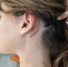 a woman with a small tattoo on her left ear