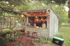 a small shed with lights on the roof and some stools in front of it