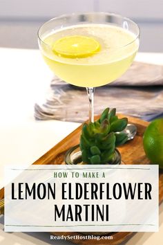 a lemon elderflower martini in a coupe glass on a wooden tray with limes