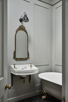 a bathroom with a sink, mirror and bathtub in it's own room