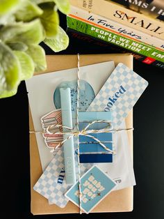 an envelope tied up with twine and some paper on top of it next to books