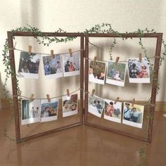 an open wooden frame with photos hanging on clothes pins and ivy growing up the sides