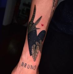 a person with a tattoo on their arm that reads bruno and has leaves in the shape of a heart