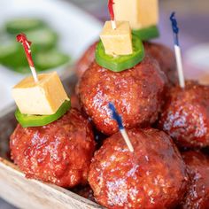 several meatballs with toothpicks and cheese on them