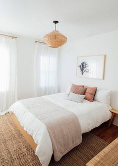 a bedroom with white walls and wood flooring