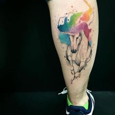 a man's leg with a colorful unicorn tattoo on it and his legs are shown