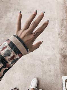 a woman's hand with black and white designs on it, holding out her fingers