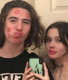 two people with makeup on their faces taking a selfie