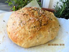 a loaf of bread sitting on top of a piece of paper next to a potted plant