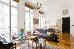 a living room filled with furniture and lots of windows