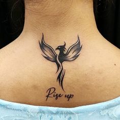 a woman with a tattoo on her neck saying rise up and a bird flying in the sky