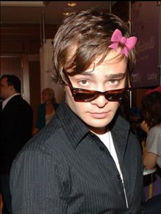 a young man wearing sunglasses and a pink bow