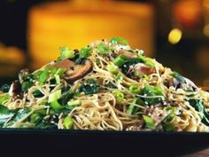 a black plate topped with noodles and vegetables