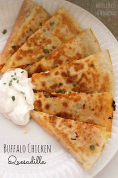 a white plate topped with quesadillas and sour cream