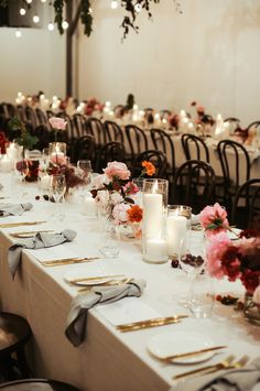 a long table is set with candles, flowers and napkins for an elegant dinner