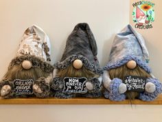 three stuffed gnomes are sitting on a shelf with their name written on the caps