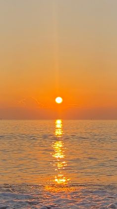 the sun is setting over the ocean with waves