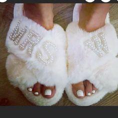 a woman's feet wearing white slippers with the word love written on them