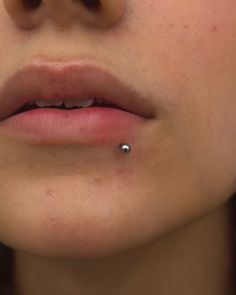 a woman with a nose piercing on her lip