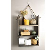 a shelf filled with toilet paper and other items next to a wall mounted candle holder