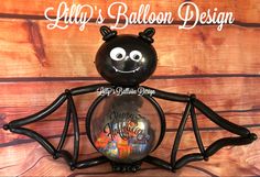 a black balloon with an image of a bat on it's back and the words, lily's balloon design