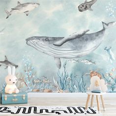 a child's room with a wall mural featuring dolphins and other marine creatures, including a stuffed animal