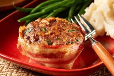 a red plate topped with meat and mashed potatoes