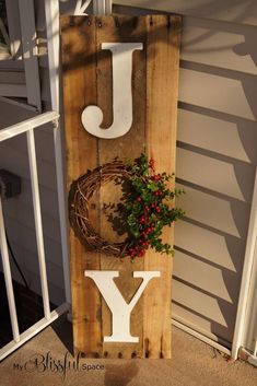 a wooden sign with the letter y on it and a plant in front of it