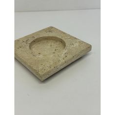 a square stone bowl sitting on top of a white table