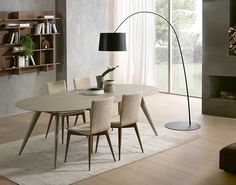 a dining room table with chairs and a lamp in front of a book shelf filled with books