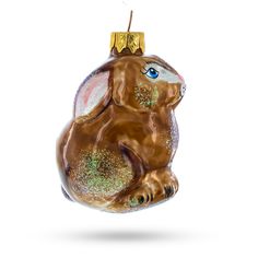 a glass ornament shaped like a rabbit with blue eyes and gold glitters