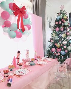 a christmas tree is in the background with balloons and other decorations on it's table