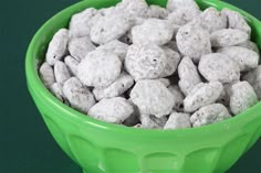 a green bowl filled with white dog food on top of a green countertop next to a black table