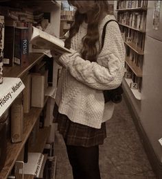 a woman standing in a bookstore reading a book