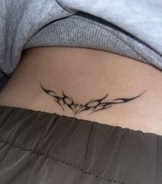 a woman with a tattoo on her stomach that has two flowers in the shape of an arrow