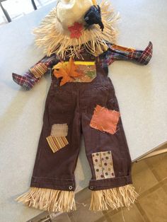 a scarecrow doll made out of old jeans and other items on a table top