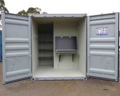 an open storage container sitting on top of a dirt field