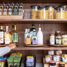 a person standing in front of shelves filled with different types of food and condiments