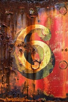 an old rusted metal surface with the letter c painted on it