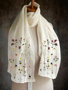 a white scarf with embroidered flowers on it