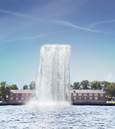 there is a large waterfall in the middle of the water with buildings on either side