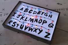 a lit up sign with letters and numbers on the front is sitting on top of a cardboard box